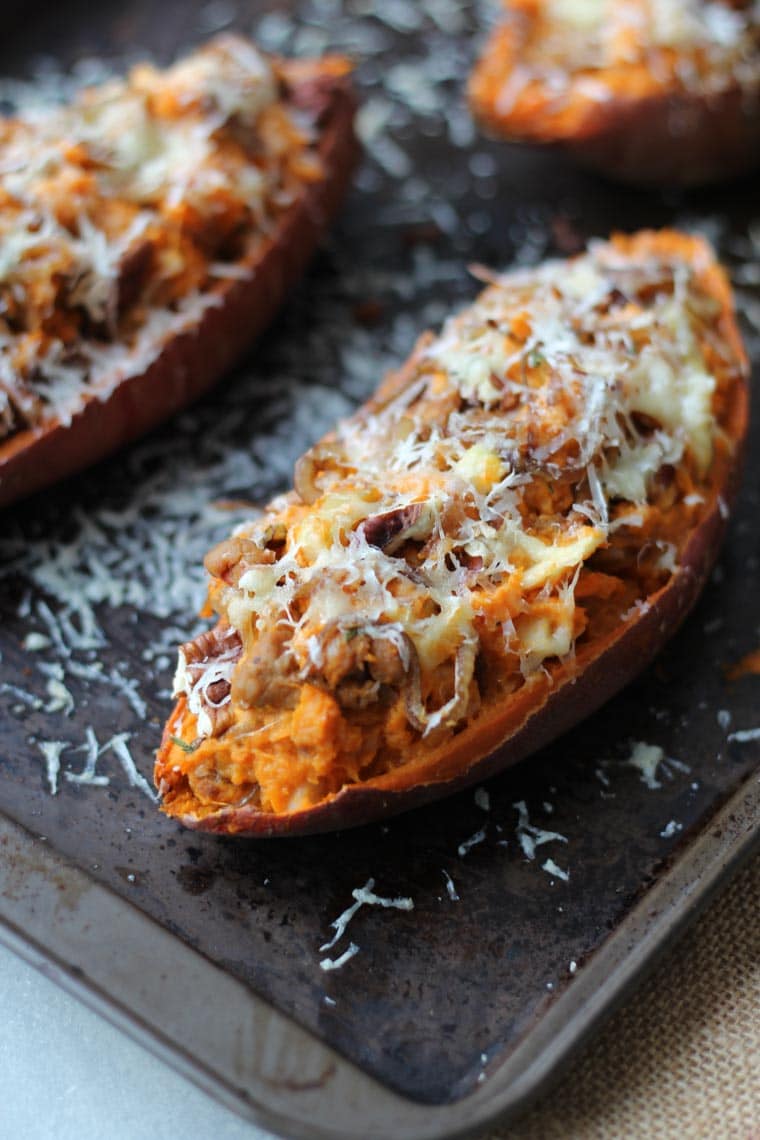 A close up of a baked sweet potato with caramelized onion and apple.