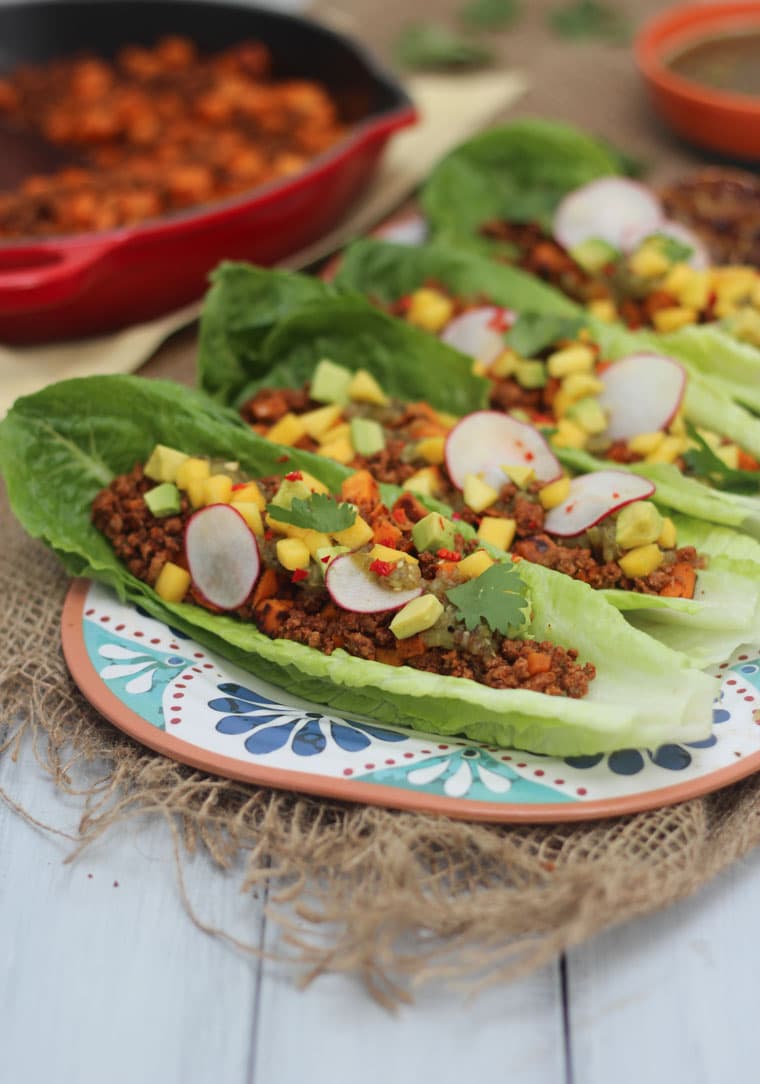 lettuce cups filled with paleo chorizo and sweet potato filling garnished with vegetables on a floral plate