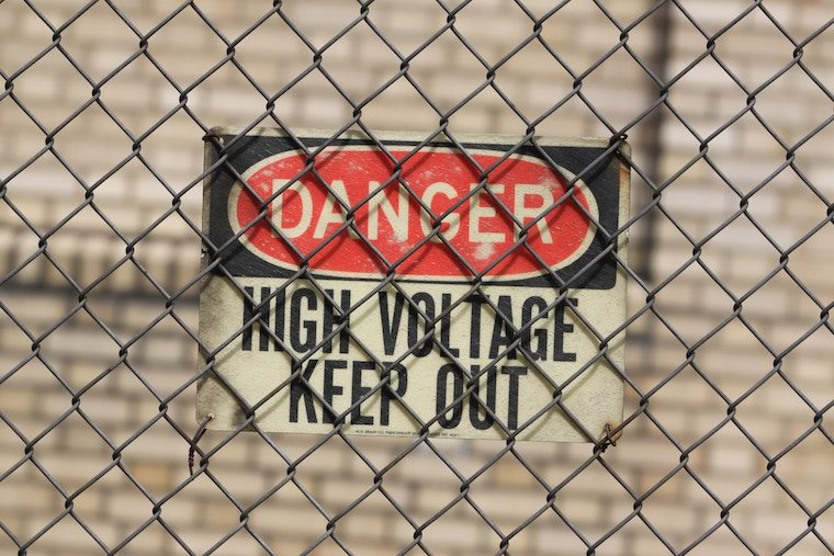 high voltage danger sign and a fence