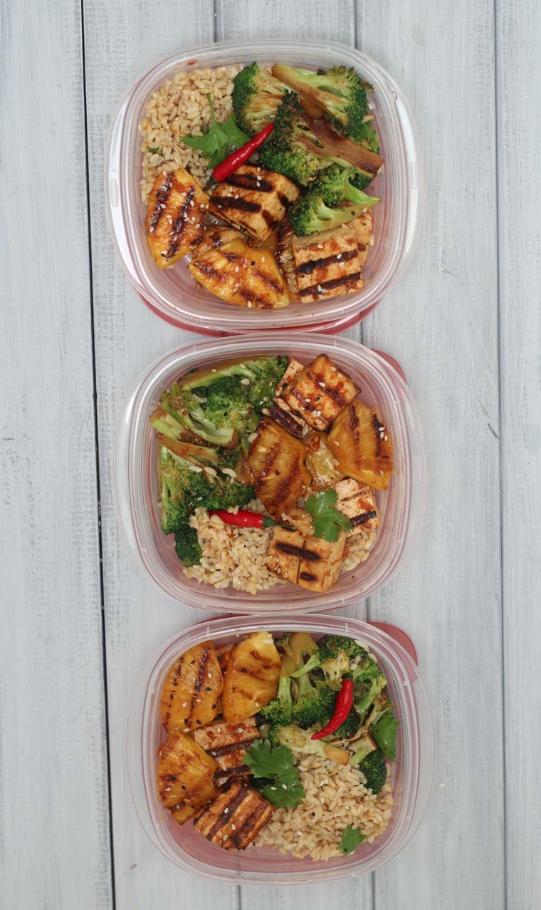 birds eye view of spicy grilled tofu and pineapple skewers in containers for meal prep