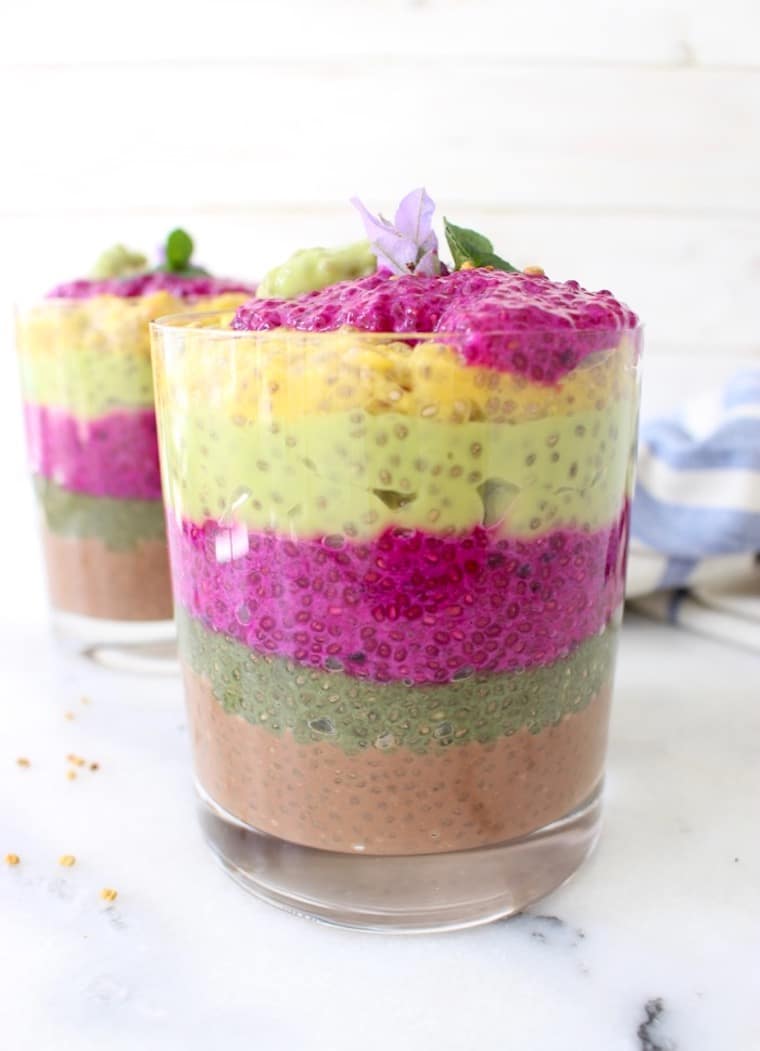 A glass cup with rainbow layered chia seed pudding.