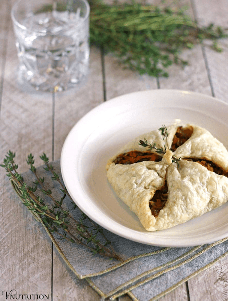 vegan lentil puff pastry pocket in a white bowl garnished with herbs 