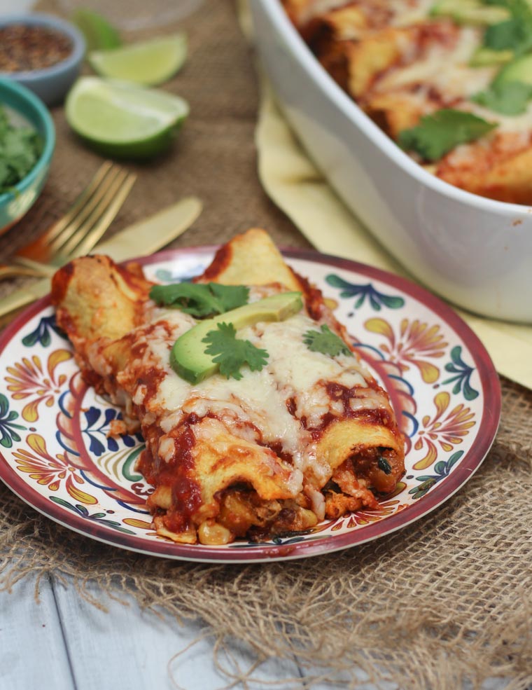 A plate with two chicken enchiladas on it.