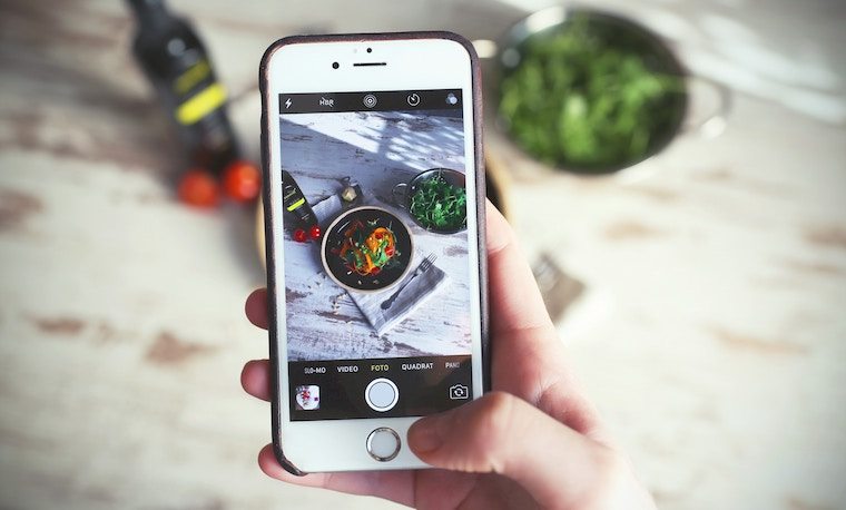 A phone taking a photo of food.