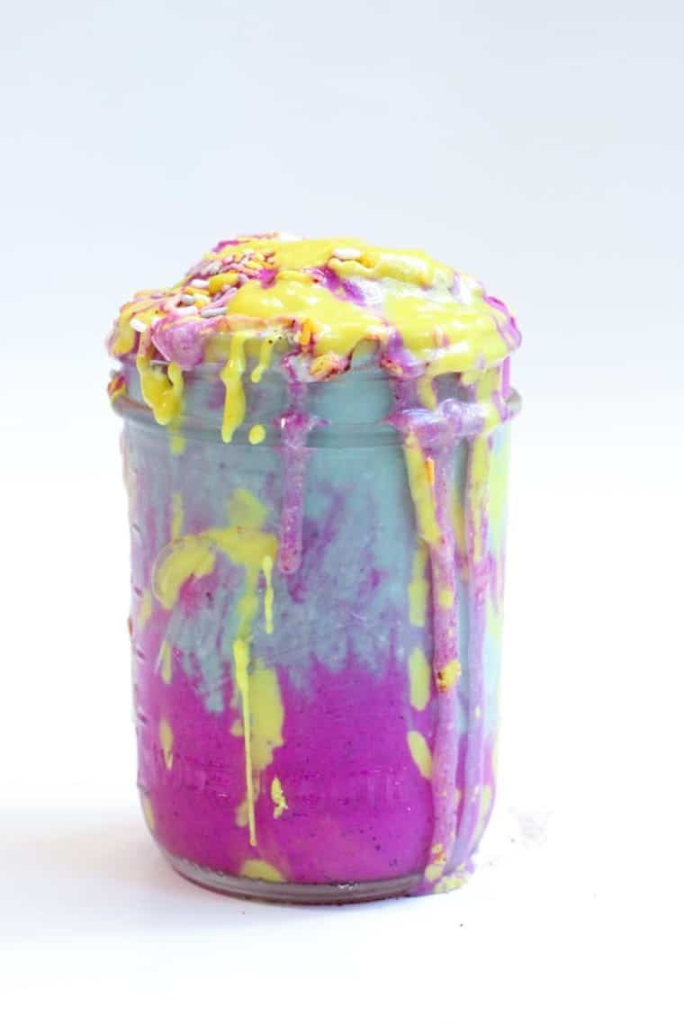 A colourful smoothie overflowing from a mason jar.