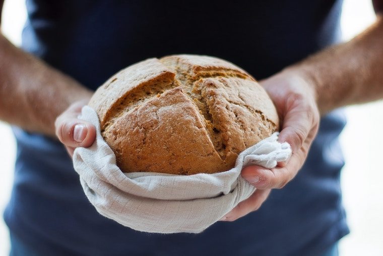 A close up of a hand holding bread.