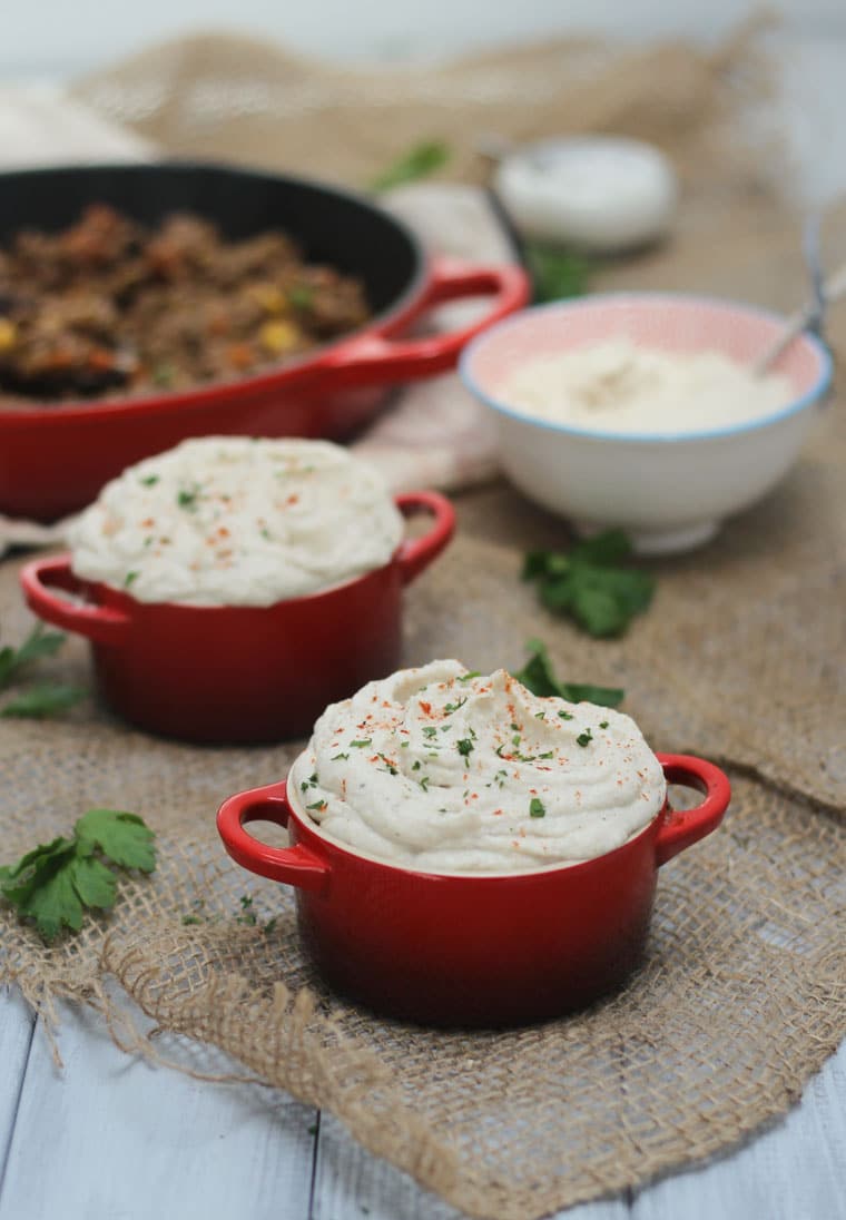 two vegan and gluten free mini shepherd's pies in red dishes 