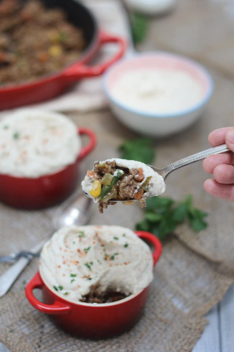 person holding a spoon taking a bite out of a keto shepherd's pie