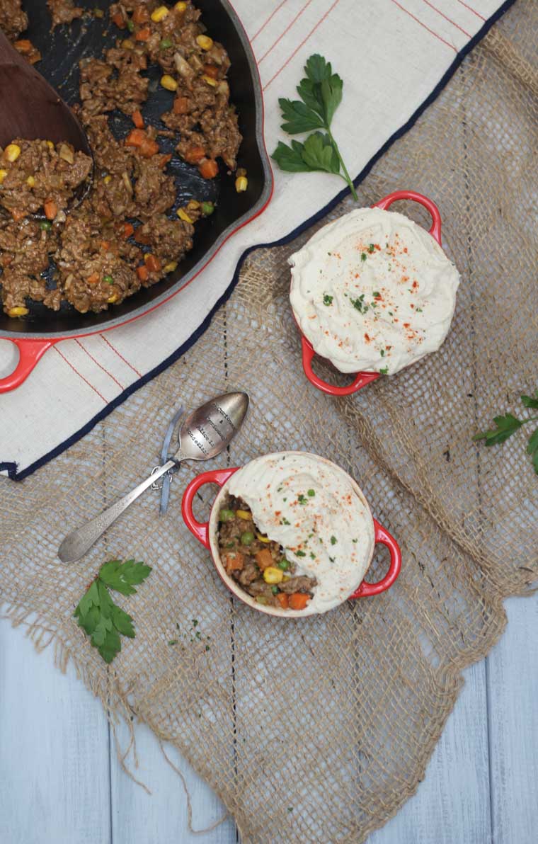 birds eye view of two gluten free mini shepherd's pies in red dishes