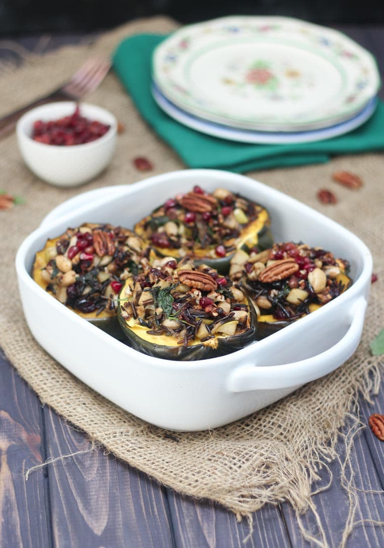 Stuffed acorn squash in a white casserole dish.