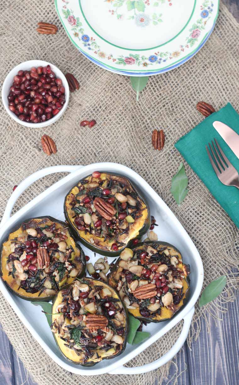 An overhead photo of a white baking dish with four stuffed acorn squash.