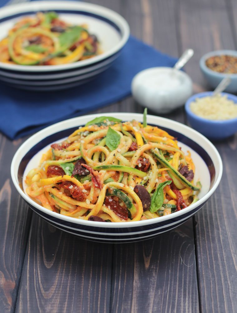 vegan vodka sauce zoodle pasta in a black and white bowl garnished with herbs 