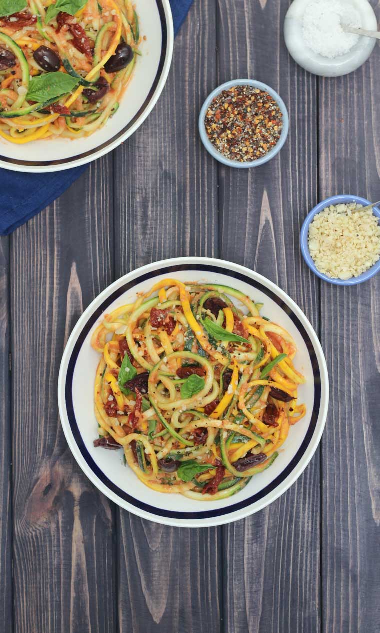 birds eye view of vegan vodka sauce zucchini noodle pasta garnished with herbs in a black and white bowl