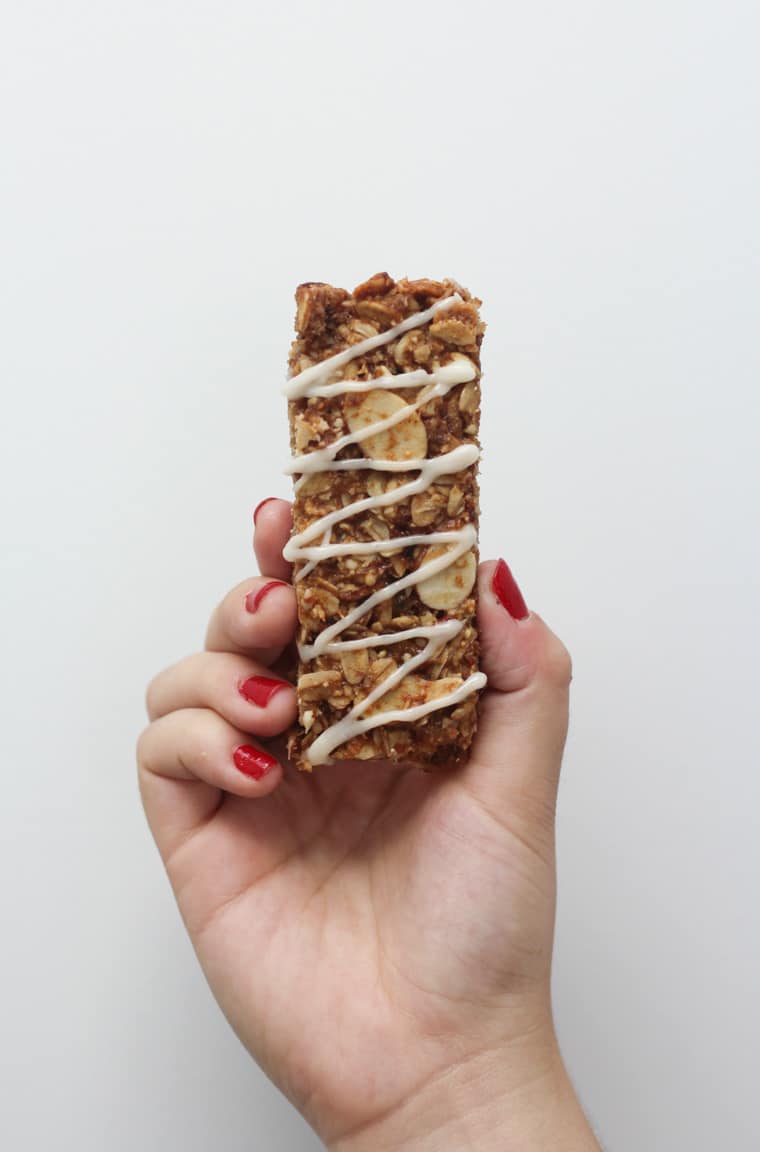 A hand holding up a vegan cinnamon bun granola bar.