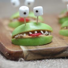 A close up of halloween apple alien smiles with marshmallow eyes.