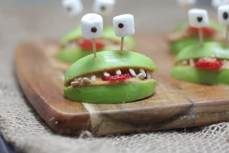 A close up of halloween apple alien smiles with marshmallow eyes.