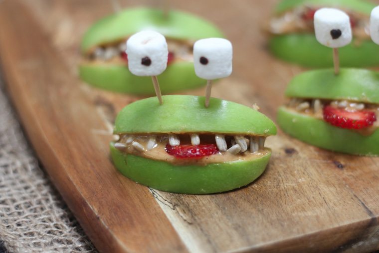 A close up of halloween apple alien smiles with marshmallow eyes.