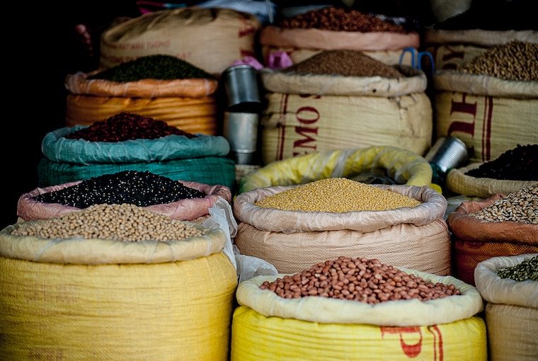 Multiple barrels filled with various beans and legumes.