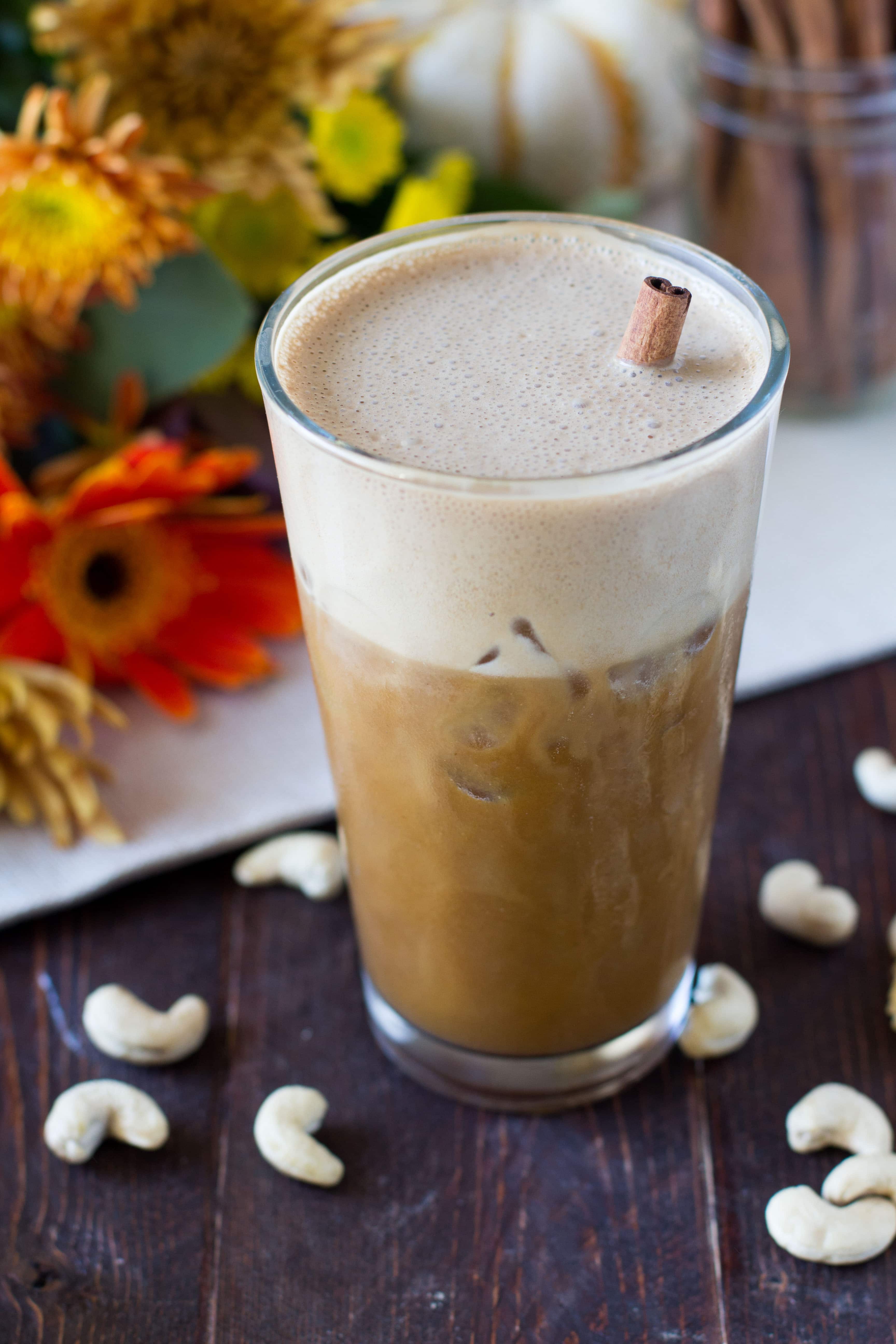 paleo pumpkin spice cold brew in a tall clear glass garnished with a cinnamon stick