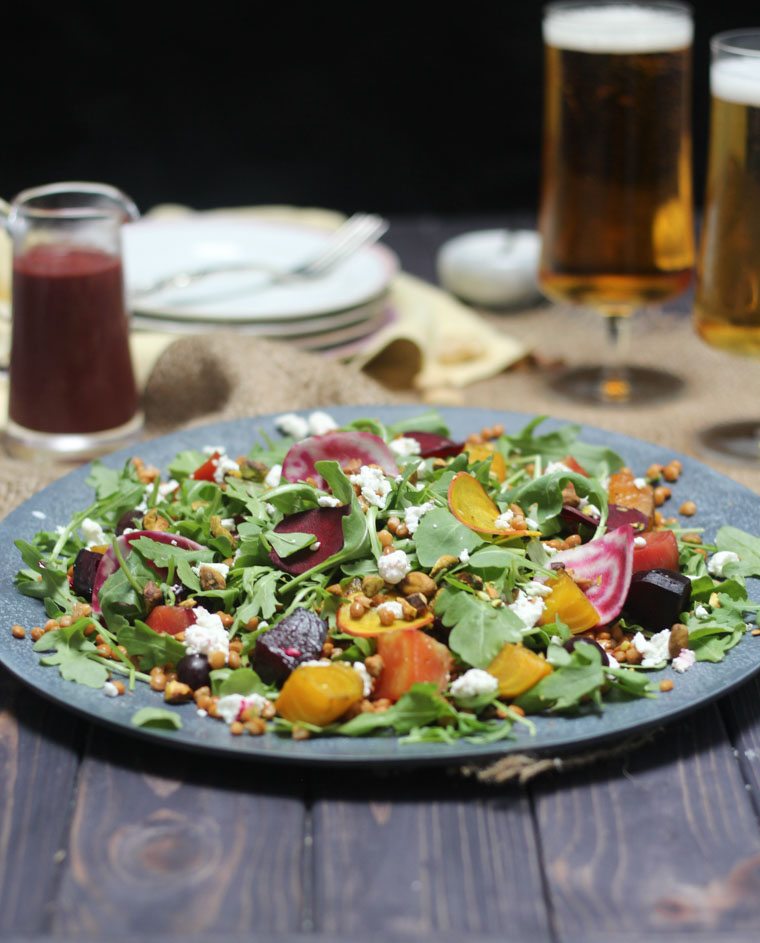 Lentil and beet salad served next to beer and dressing.