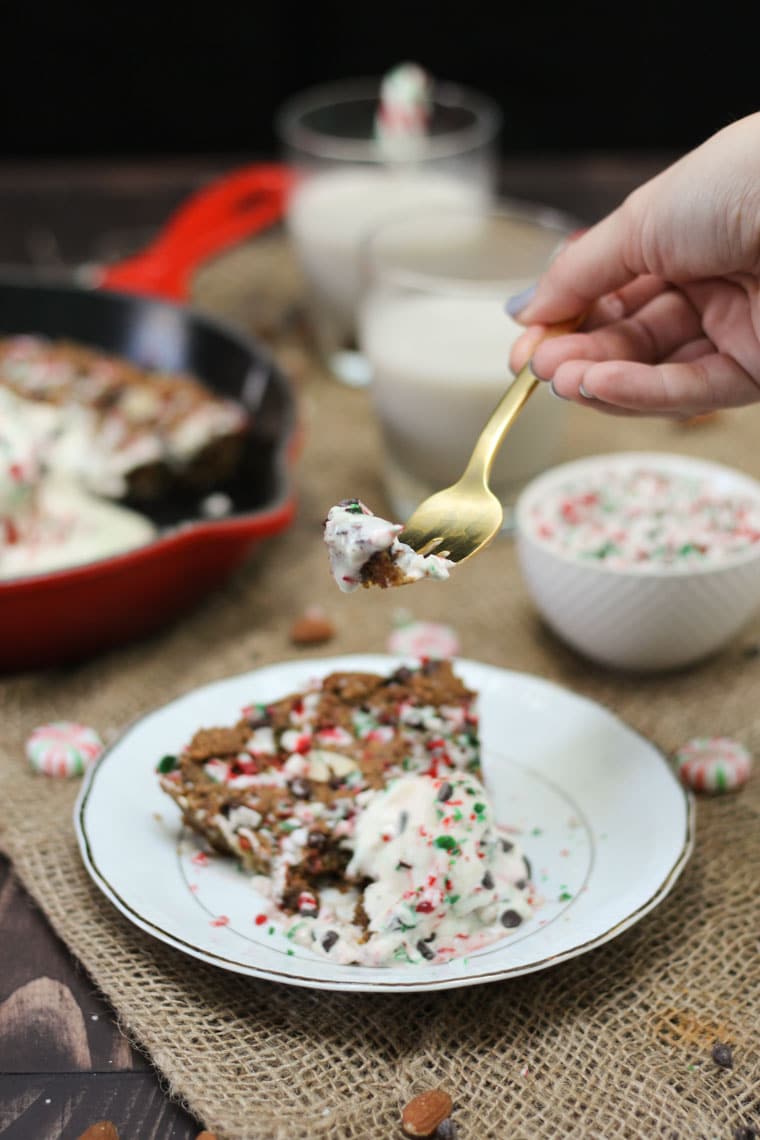 Hand holding a bite of cookie dessert on a fork. 