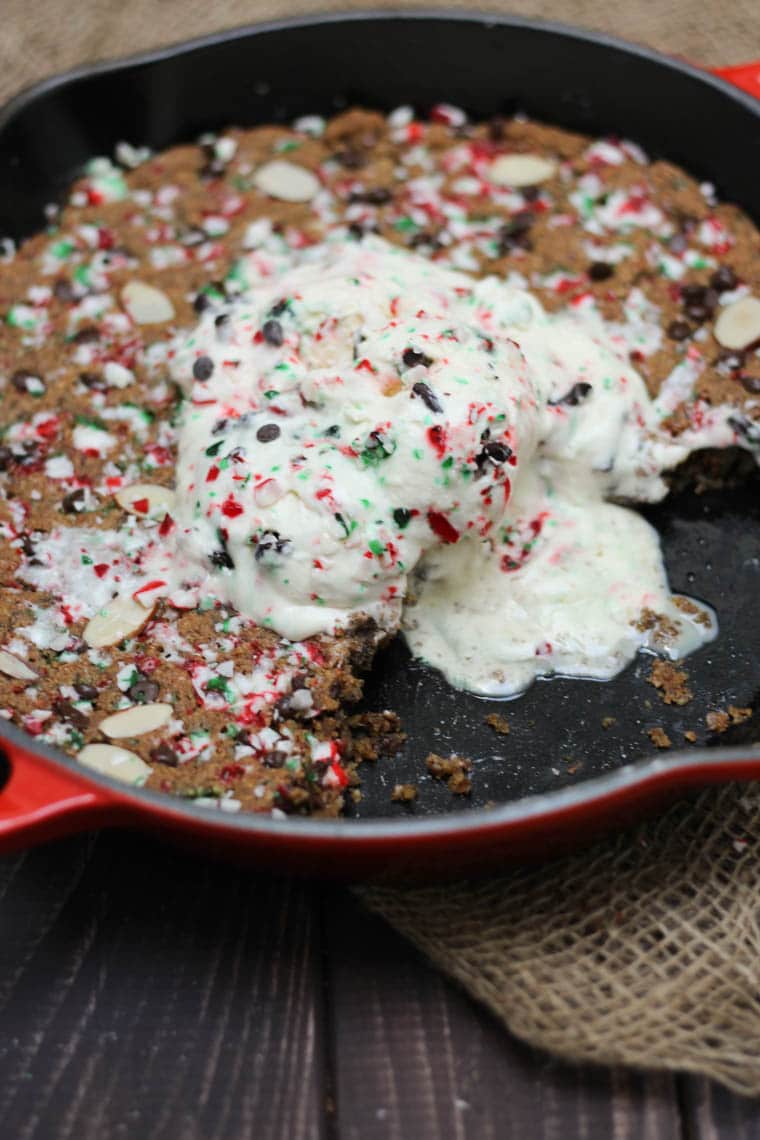 Candy cane chocolate cookie in a skillet topped with ice cream. 