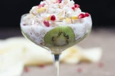 A glass with mango kiwi vegan coconut rice pudding.
