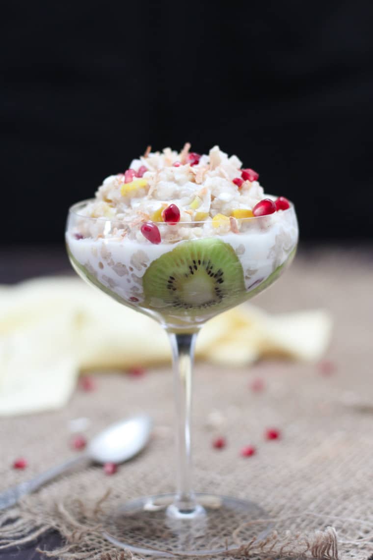 A glass with mango kiwi vegan coconut rice pudding.