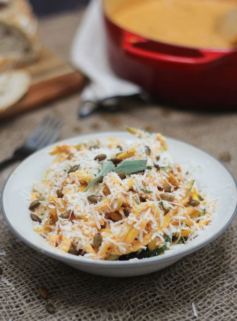 low carb keto pumpkin zoodles with spiced pumpkin seeds in a white bowl