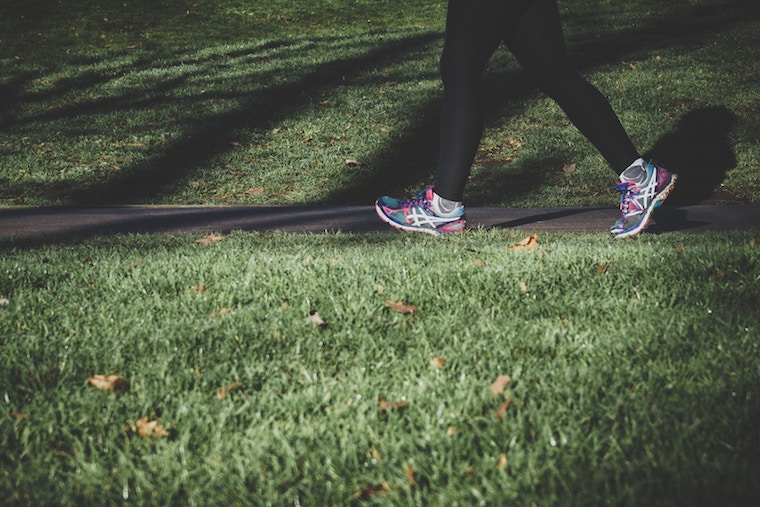 Person running on path to help relieve stomach cramps. 