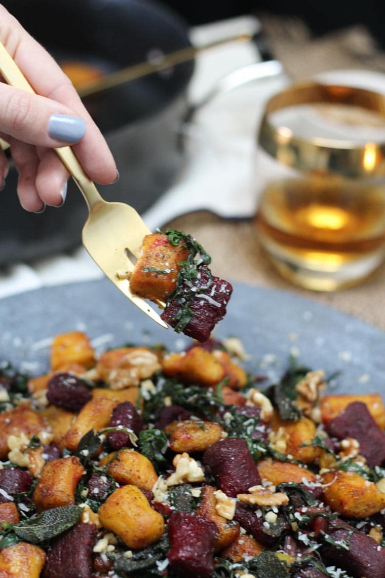 Fork digging into a platter of gnocchi.