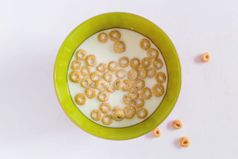 A green bowl with milk and cereal.