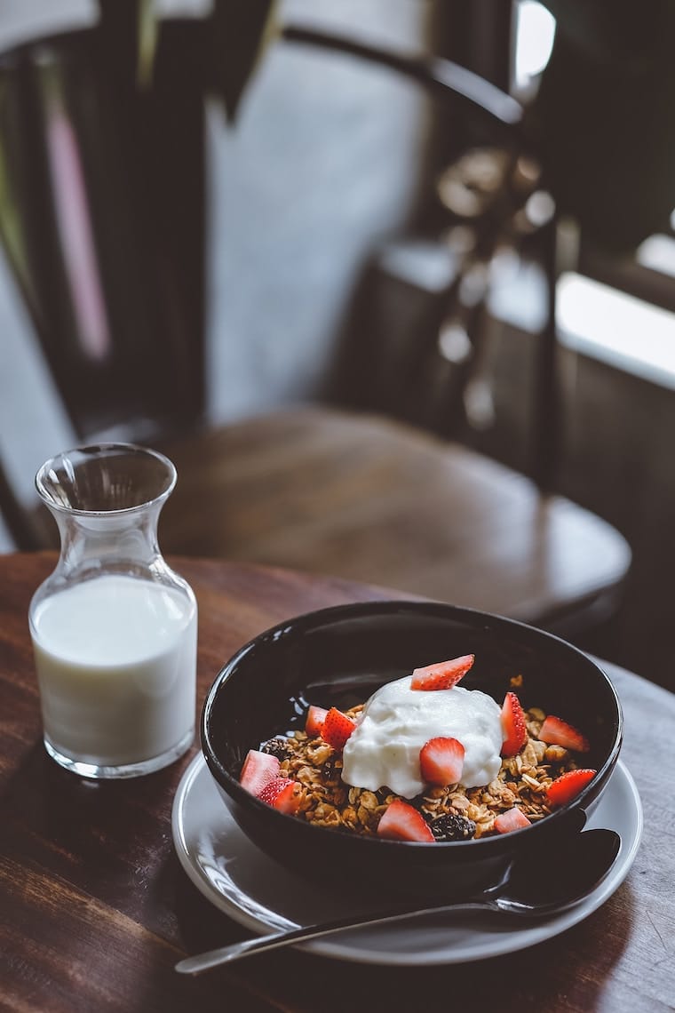 A table with breakfast on it and a glass of milk.