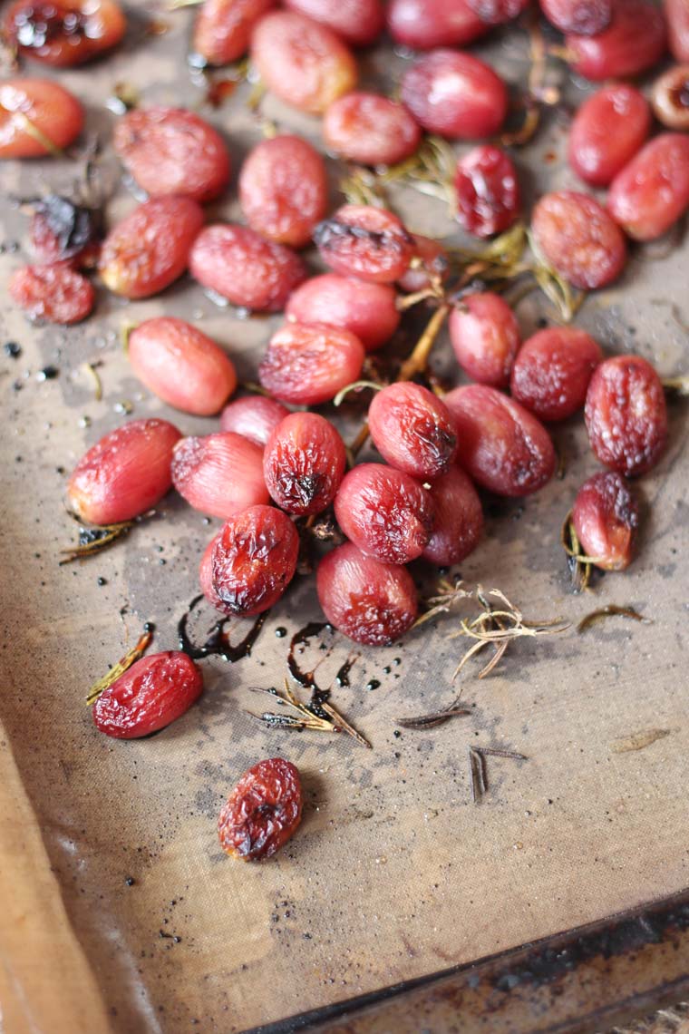 roasted grapes with herbs on a wooden surface