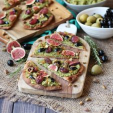 Vegan Olive Pesto Flatbread with Olives from Spain, Roasted Grapes and Figs This Vegan Olive Pesto Flatbread with Olives from Spain, Roasted Grapes and Figs is a perfect plant-based healthy holiday appetizer to feed a crowd! Serves 16 Gordal olives from Spain Pesto 1/2 cup pistachios (shelled) 1 cup pitted Gordal olives from Spain 1 garlic clove, minced 1 cup arugula ¼ cup extra virgin olive oil Pepper, to taste Flatbread 3 tbsp extra virgin olive oil, divided ½ onion, thinly sliced 1 ½ cups red grapes 2 sprigs rosemary 6 small whole grain naan breads 4 figs, thinly sliced ¼ cup pitted Dark Hojiblanca olives from Spain, thinly sliced ¼ cup crushed pistachios In a food processor, puree the pistachios until they reach a powder like consistency, then add in the Gordal olives from Spain, garlic, arugula and oil. Season with pepper, to taste. Set aside. Preheat oven to 450 F. Heat a tablespoon of oil in a nonstick skillet over medium-low heat. Add in the onions and saute until dark and caramelized, about 50 minutes. Set aside. Meanwhile, place the grapes and rosemary on a baking sheet and drizzle with a tablespoon of oil. Place the naans on baking sheets and drizzle with the remaining tablespoon of oil. Roast the grapes for 20-25 minutes or until caramelized, and the flatbread for 5-10 minutes just until toasted around the edges. When ready to serve, smear the olive pesto all along the toasted naans. Top with the roasted grapes, figs, Dark Hojiblanca olives from Spain, caramelized onions and pistachios. Enjoy!