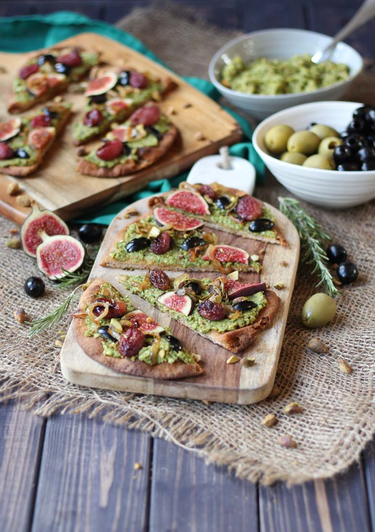 vegan pesto and olive flatbread garnished with roasted grapes and figs