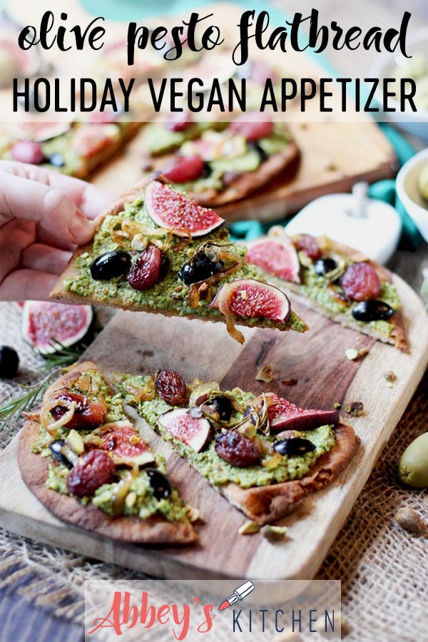 pinterest image of vegan flatbread with pesto, olives, and figs on a wooden surface with text overlay