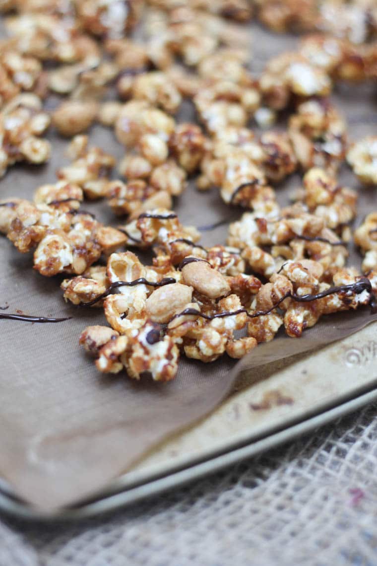 Close up of caramel peanut popcorn with chocolate drizzle. 