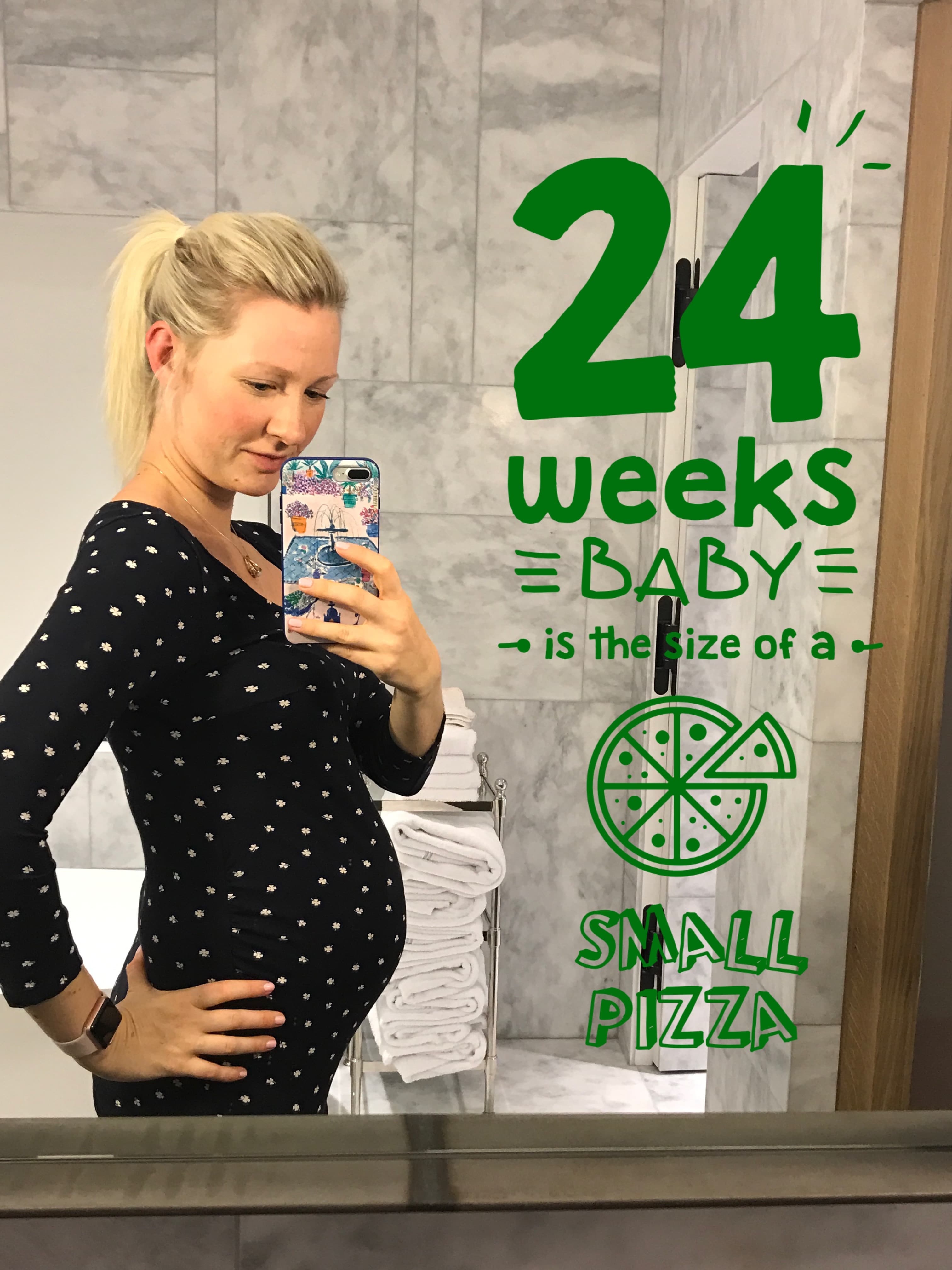 pregnant woman taking a mirror selfie at 24 weeks