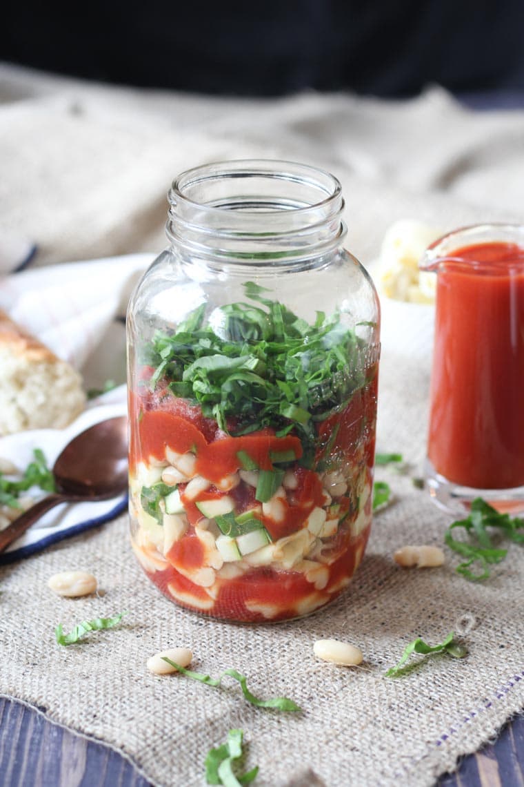 vegan italian pasta soup in a mason jar garnished with fresh herbs