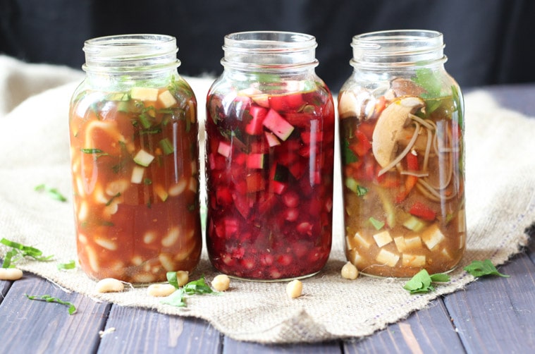 close up of three vegan mason jar soups in tall clear jars