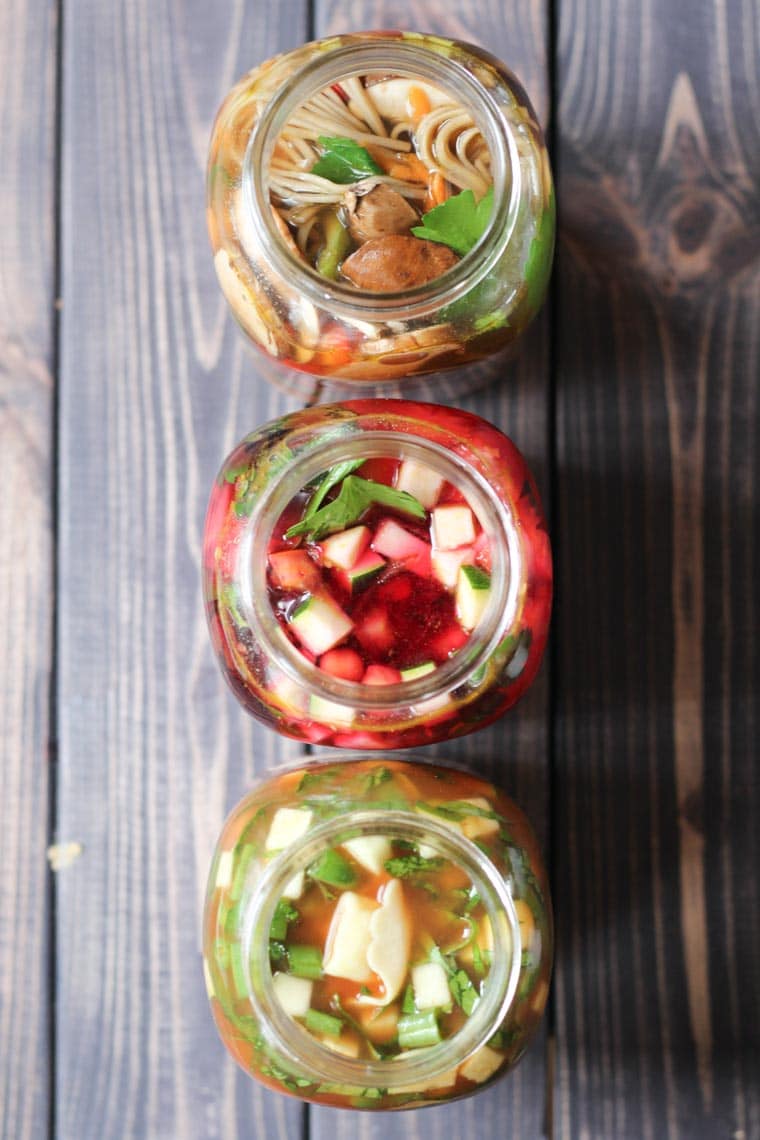 birds eye view of three vegan mason jar soup recipes for lunch on a wooden table