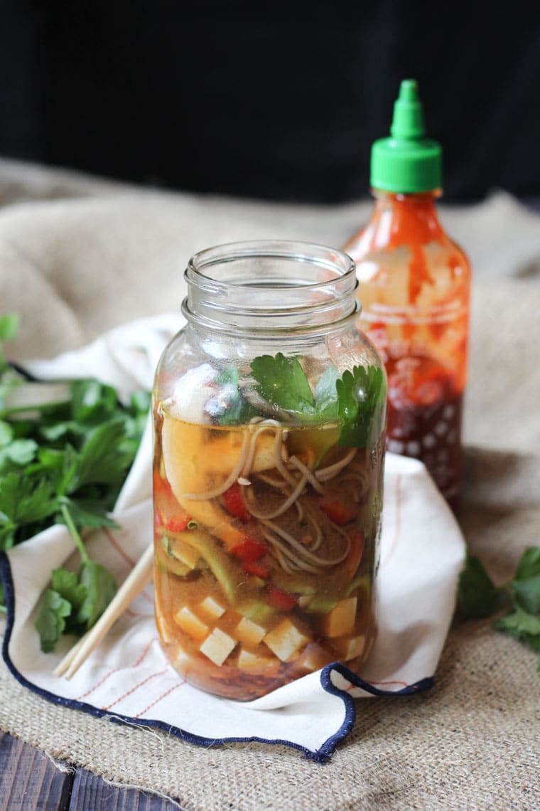 vegan miso noodle soup in a mason jar garnished with fresh herbs