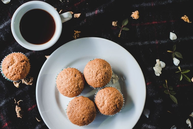 A white plate with four muffins.