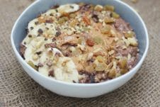 A bowl of chocolate zucchini bread oatmeal zoats in a grey bowl on a brown background.