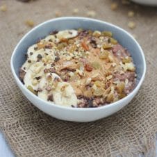 A bowl of chocolate zucchini bread oatmeal zoats in a grey bowl on a brown background.