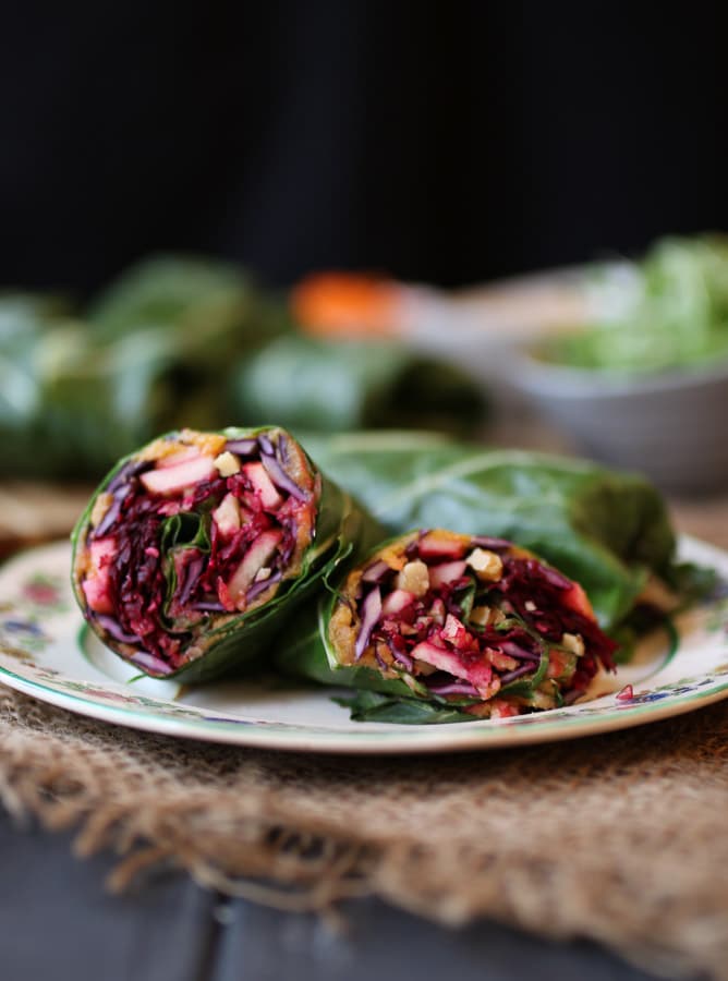 close up image of vegan sweet potato and apple collard green wrap on a white plate