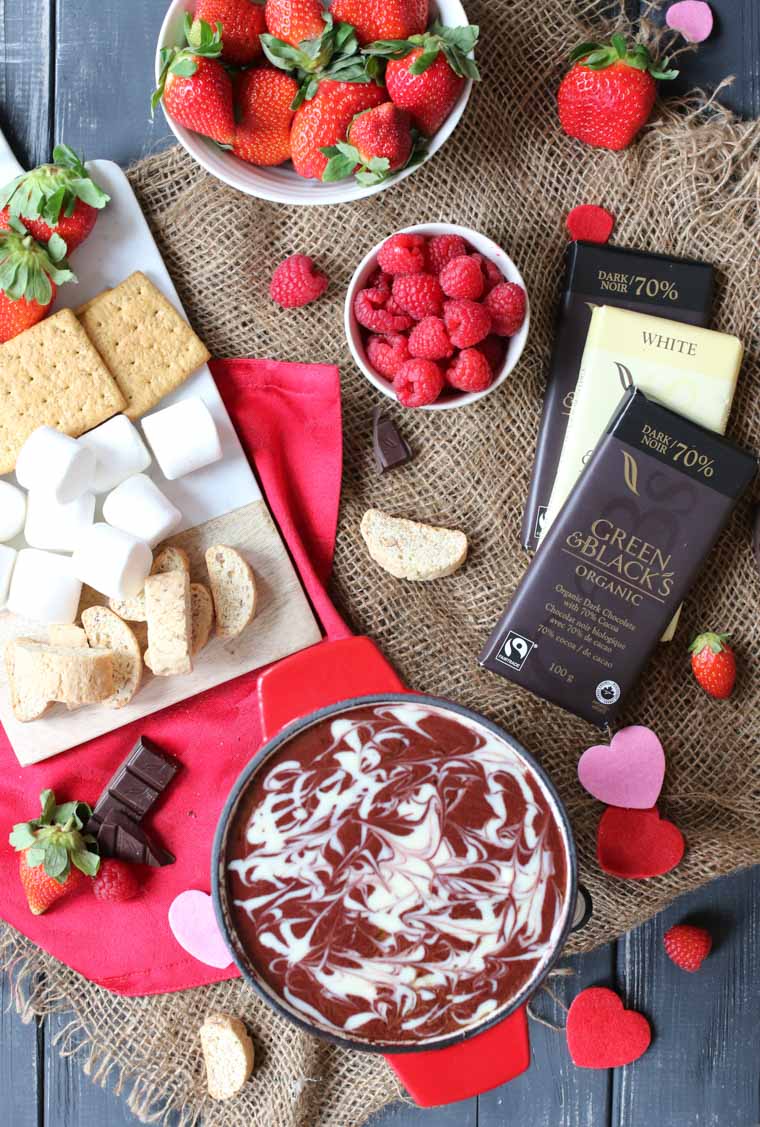 birds eye view of red velvet fondue with chocolate, fruit, marshmallows, and crackers 