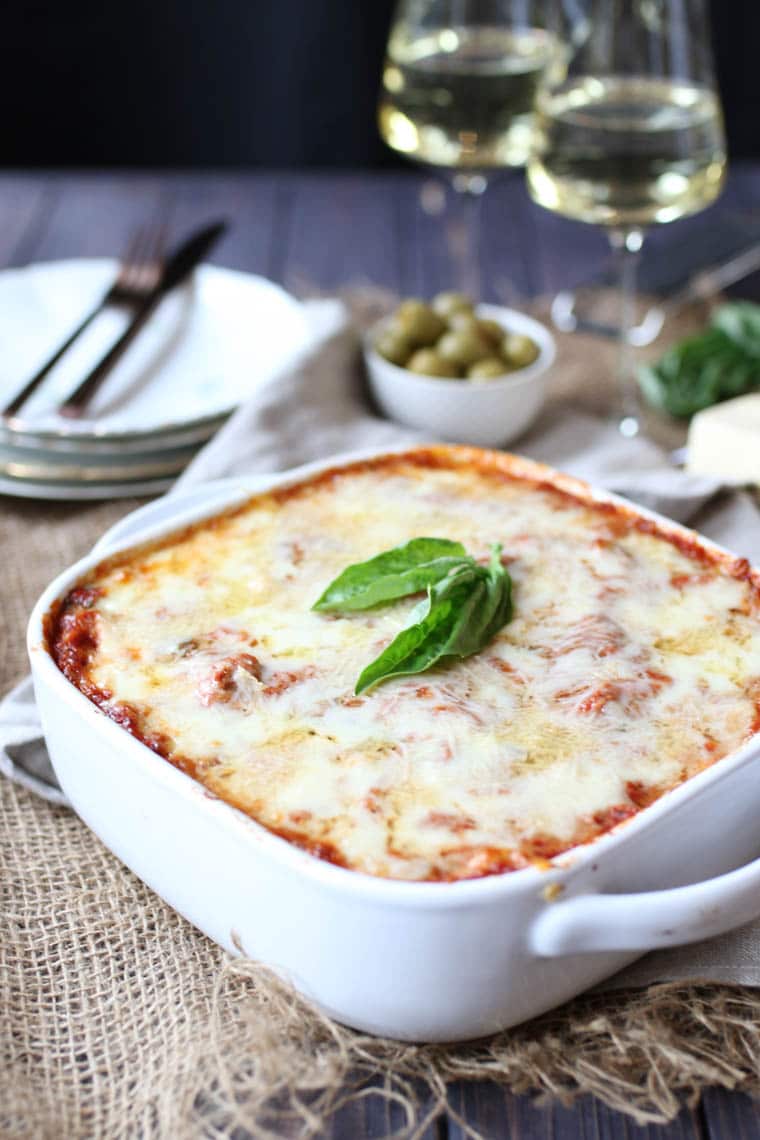 A white baking dish holding a zucchini lasagna with turkey sausage.