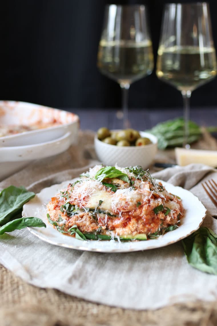 A slice of gluten free lasagna on a white dish.